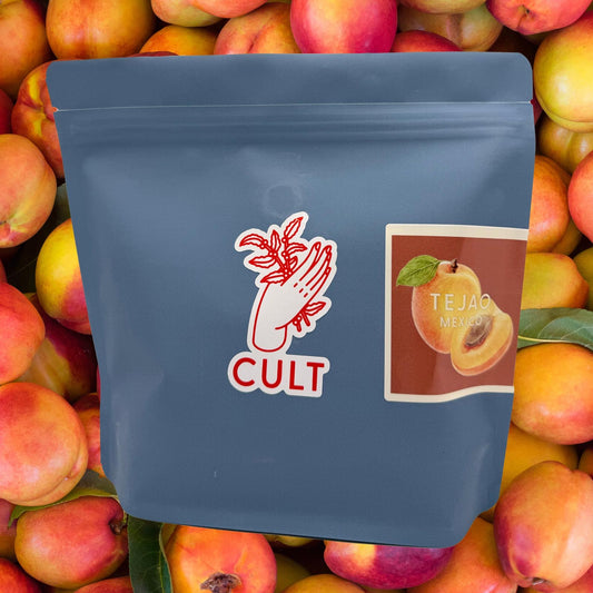Blue coffee bag with 'CULT' branding and a label for 'TEJAO MEXICO' on peach background. 