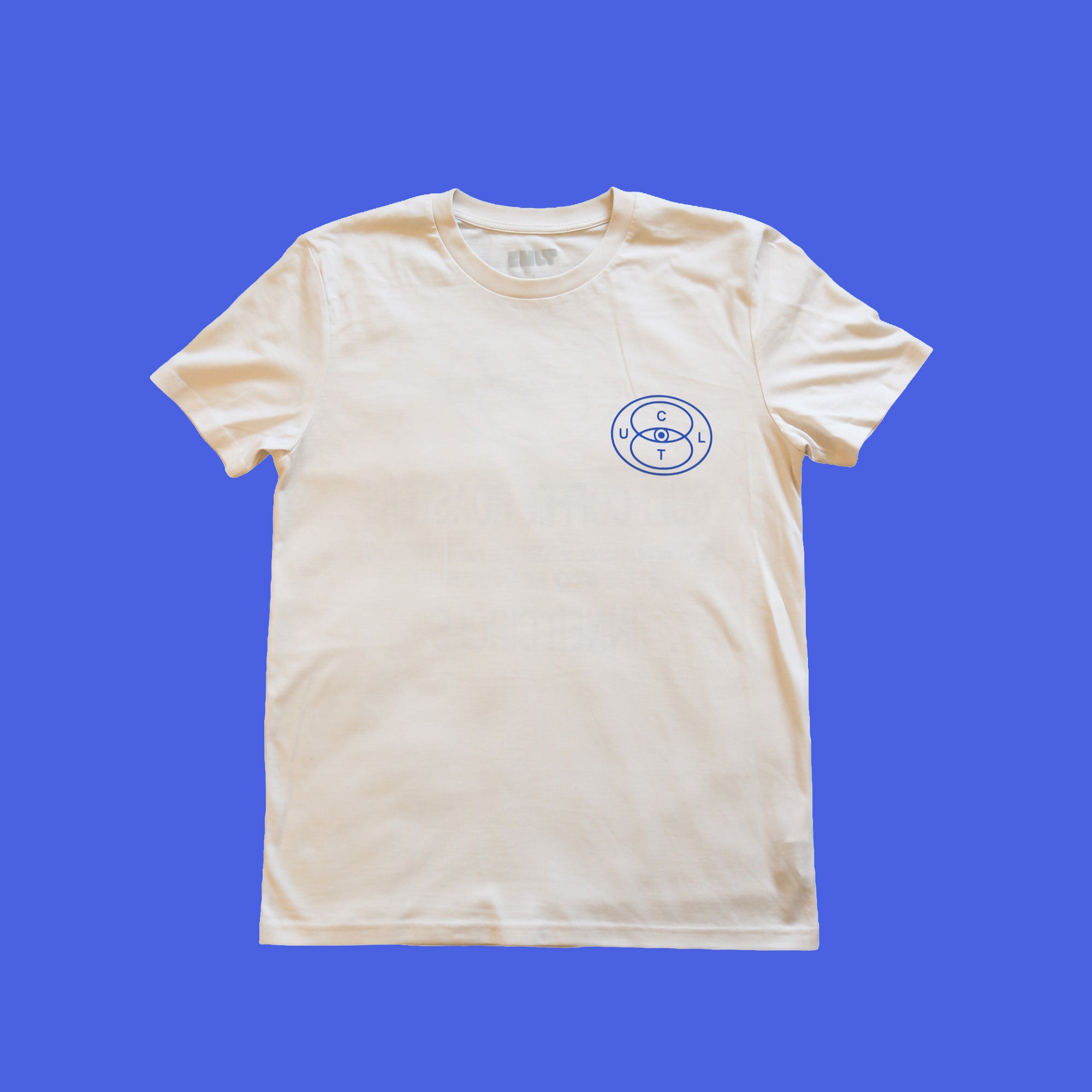 Cream t-shirt on blue background, blue Cult logo on right side. 