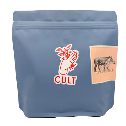 Blue coffee bag with 'Cult' logo and 'Highland Co-op Guatemala' label on a white background